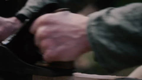 Carpenter's hands using hand plane to flatten plank of wood for cross Stock Footage 271200604