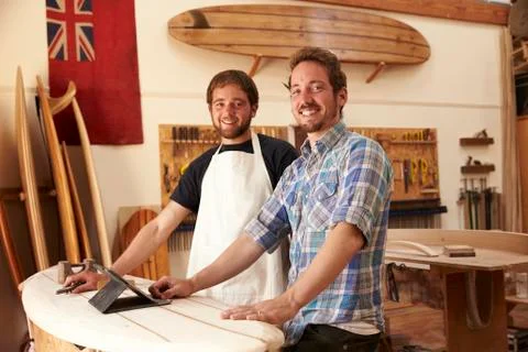 Carpenters In Surfboard Workshop Using Digital Tablet Stock Photos