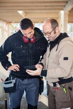 Carpenters Using Digital Tablet At Site 写真素材