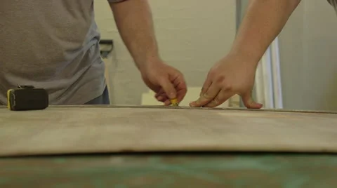 Carpenters Using Measuring Tape to Mark Section of Plywood Stock Footage 61503818