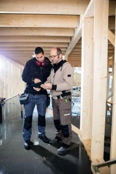 Carpenters Using Tablet Computer At Site 写真素材
