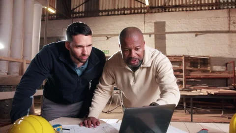 Carpentry, collaboration and laptop with men in warehouse together for Stock Footage 338044166