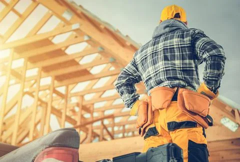 Carpentry Construction Worker in Front of Newly Developed Wooden Skeleton Hou Foto stock