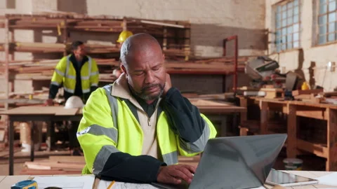Carpentry, neck pain or man in workshop with laptop, burnout or joint strain Stock Footage 338100800