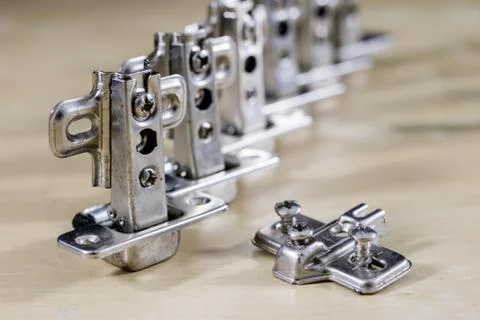 Carpentry tools and accessories on a workshop table. Hinges and screws togeth Stock Photos