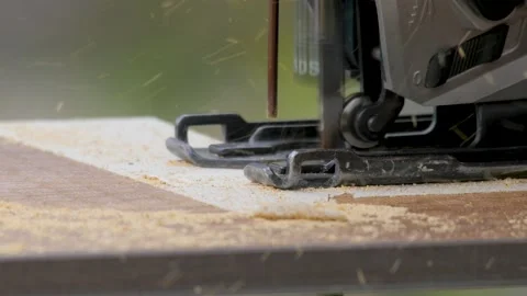 Carpentry tools. Close up of electric jigsaw in action. Manufacturing of Stock Footage 155686051