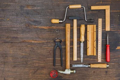 Carpentry tools on a dark rustic wood background. Overhead, a copy of the space Stock Photos