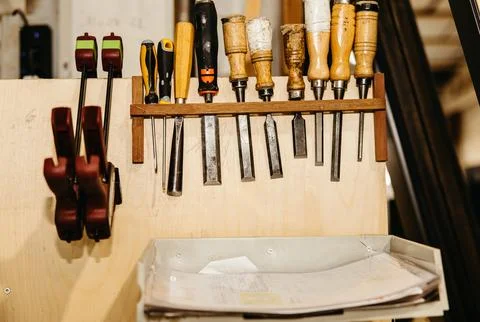 Carpentry tools hanging on a workshop wall Stock Photos