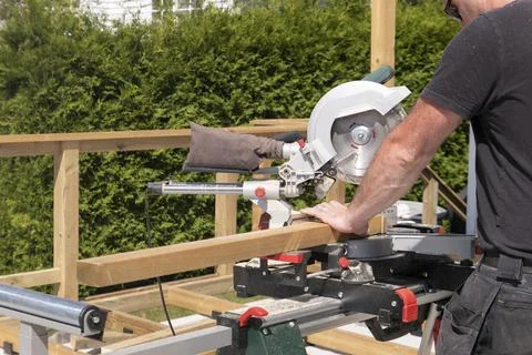 Carpentry worker using worm drive circular saw to cut boards Stock Photos