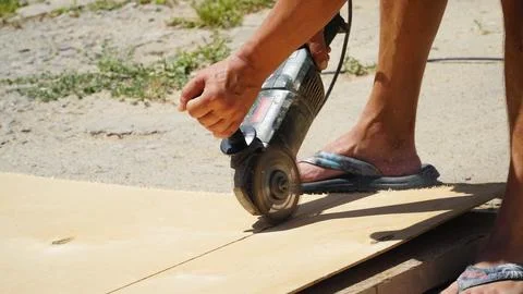 Carpentry works. A carpenter cuts an OSB board with an electric jigsaw. Woo.. Stock Photos