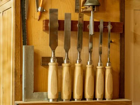 Carpentry workshop. Instruments. Close-up of tool kits hanging on the wall. Stock Photos
