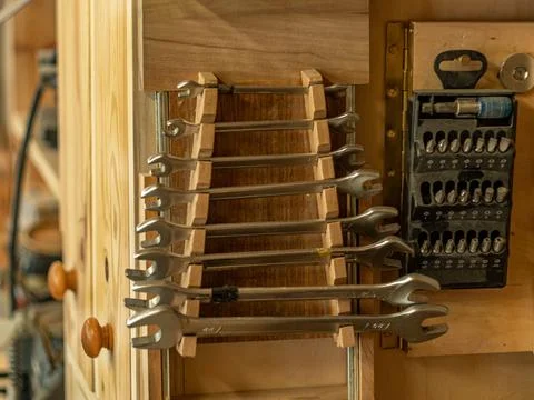 Carpentry workshop. Instruments. Close-up of tool kits hanging on the wall. Stock Photos