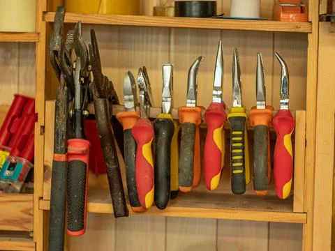 Carpentry workshop. Instruments. A set of pliers hangs on the shelf. Stock Photos