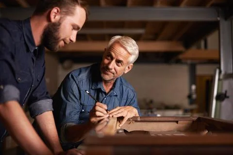 Carpentry workshop, learning and man with apprentice teaching expert tips and Stock Photos