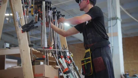 Carpentry workshop - man walks in a carpentry workshop and takes an instrument Stock Footage 157297210