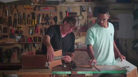 Carpentry Workshop of Master Carpenter and Apprentice Measuring Wood with R.. Stock Photos