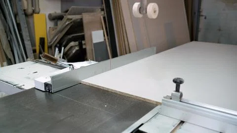 Carpentry workshop sliding table saw with white particleboard panel against Stock Photos