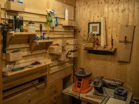 Carpentry workshop. On the wall are shelves with various tools and equipment. Stock Photos