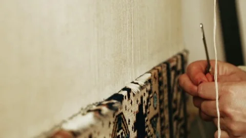 Carpet weaving. Turkish woman weaving a carpet with peace of genuine camel wool Stock Footage