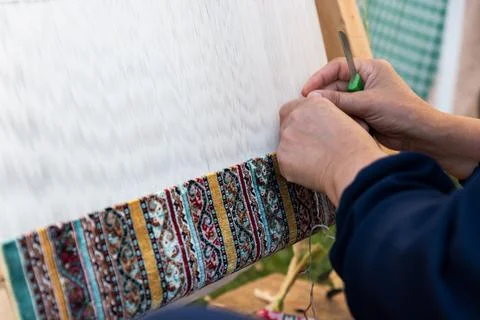 Carpet weaving using traditional techniques on a loom. , close-up of weaving and Stock Photos
