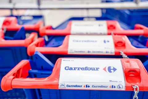 Carrefour shopping cart. Pushcart at a supermarkets parking lot. Stock Photos