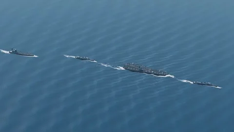 Carrier strike group in column line astern aerial open ocean blue ocean loop Stockbeeldmateriaal 343865359