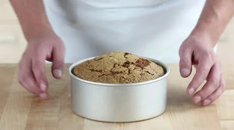 A carrot cake being removed from a baking tin Stock Footage 24671669