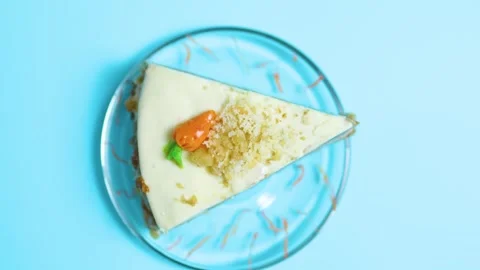 Carrot cake slice with cream cheese frosting, walnut crumble and icing carrot on Stock Footage 321532355