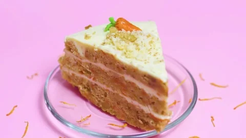 Carrot cake slice layers, creamy white frosting, crushed nuts on glass plate, Stock Footage 321532889