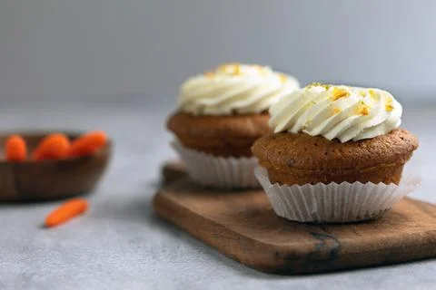 Carrot cupcake on a wooden board, ingredients on the back Stock Photos