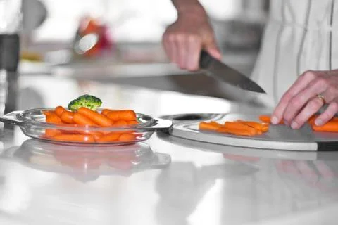 Carrot cutting in kitchen Stock Photos