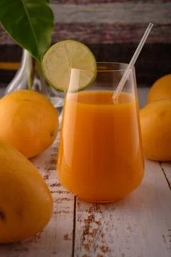 Carrot drink macro with lime slice on white vintage wooden desktop with mango Stock Photos