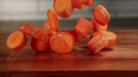 Carrot slices falling on cutting board in slow motion Stock Footage 156809690