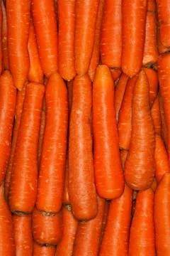Carrots background pile. Ordered vertically. Healthy food. Stock Photos