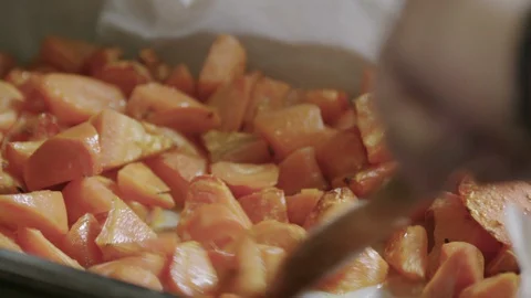 Carrots being stirred in  a tray out of the oven slow motion Stock Footage 129015895
