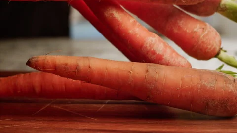 Carrots falling on cutting board in slow motion Stock Footage 158307691