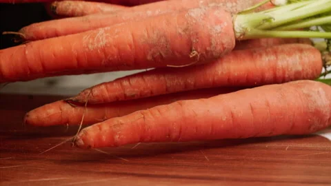 Carrots falling on cutting board in slow motion Stock Footage 158367956