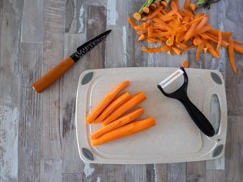Carrots peeled lying on the table, next to a knife for peeling vegetables and Stock Photos