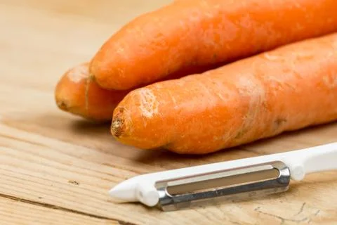 Carrots with peeling knife on the table Foto stock
