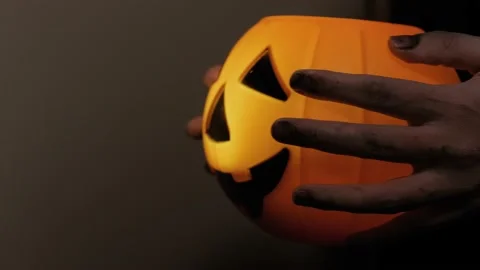 Carry the pumpkin head with your hands disguised as zombies. Halloween attribute Stock Footage 141899251