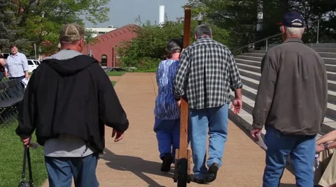 Carrying a Cross on a wheel with small crowd in front of steps outdoors 스톡 동영상 45362212