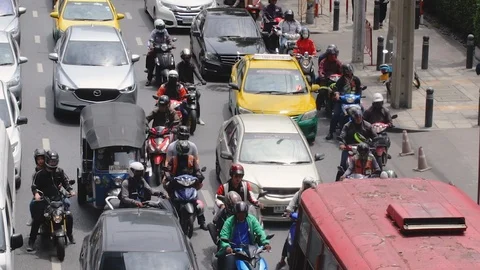 Cars and motorcycle accelerating on congested street in Sathorn Stock Footage 115959895