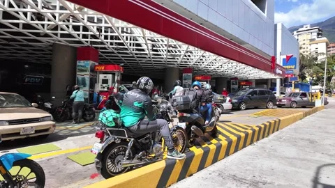 Cars and motorcycles queue for hours at a gasoline station in Caracas Stock Footage 327451927