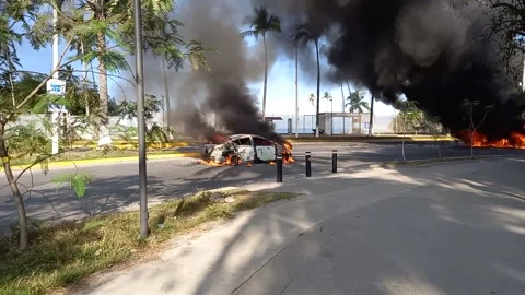 Cars Burn and Explode During Cartel Retaliation in Puerto Vallarta, Mexico, Puer Stock Footage 329800579