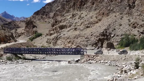 Cars crossing the bridge in queue over the river surrounded by rocky hills Stock Footage 211453311