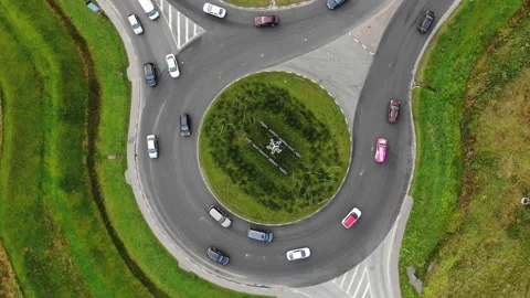 Cars drive around large turning circle in rural area 库存影片 167478392