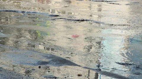 Cars drive on a bad, bumpy road with holes, muddy puddles and cracks. Video stock 152719355