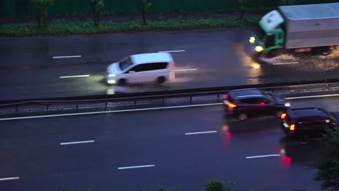Cars drive on the road in the rain in the evening Stock Footage