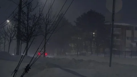 Cars drive slowly down the road during a snowstorm at night in Dartmouth, Canada Stock Footage 264380153
