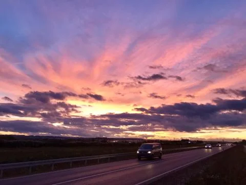 Cars driving during dramatic sunset Stock Photos